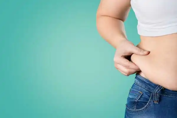 Image of woman pinching her love handles to show weight gain Sunderland